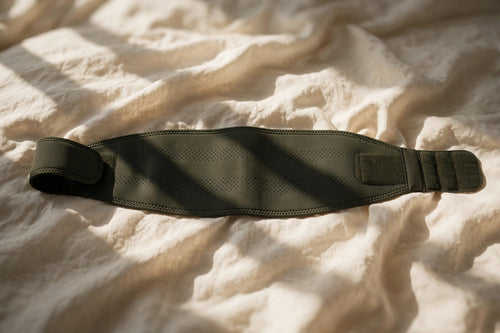 Ember Sweat Waist Trimmer belt folded on oak with cream linen towel
